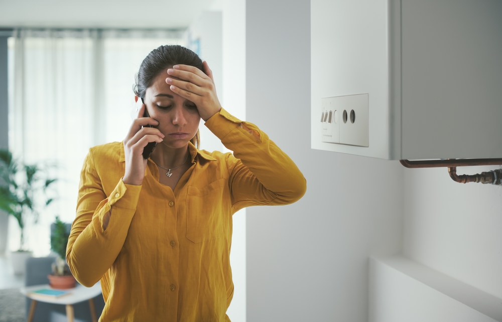 worried and stressed woman calling a technician for boiler breakdown services